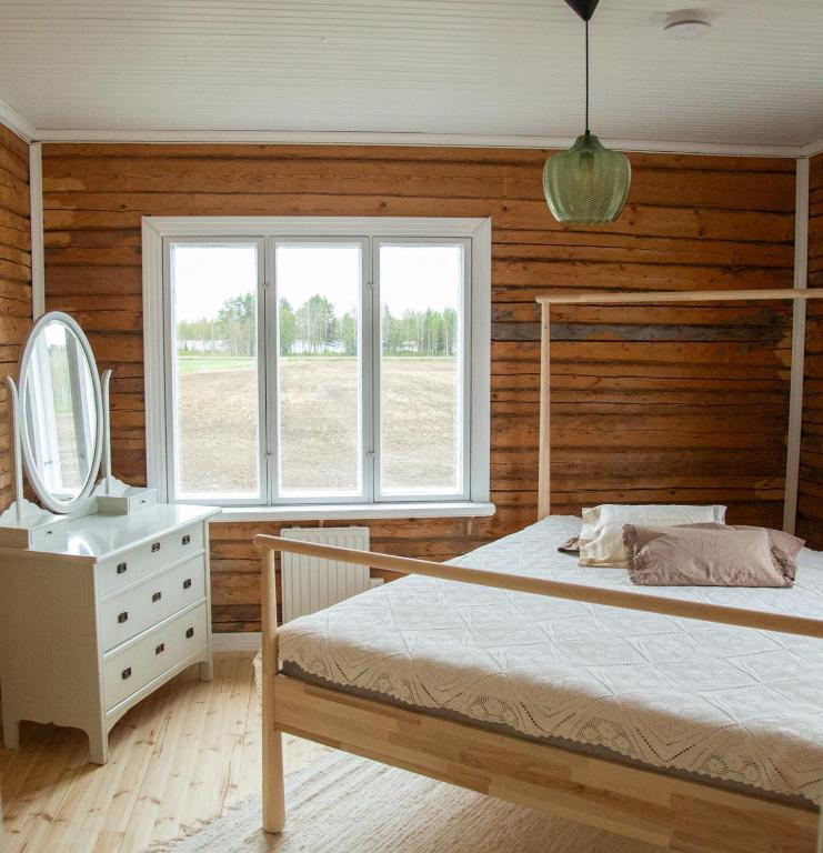 a bedroom with a bed and a mirror and a sink at Villa Onni in Kauhajoki