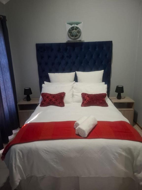 a bed with a red and white blanket and pillows at 77 Pendleberry Grove in Warmbaths