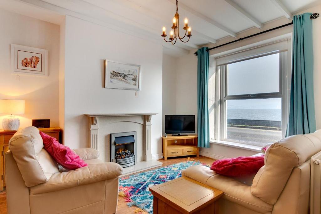a living room with two chairs and a fireplace at St Judes in The Mumbles