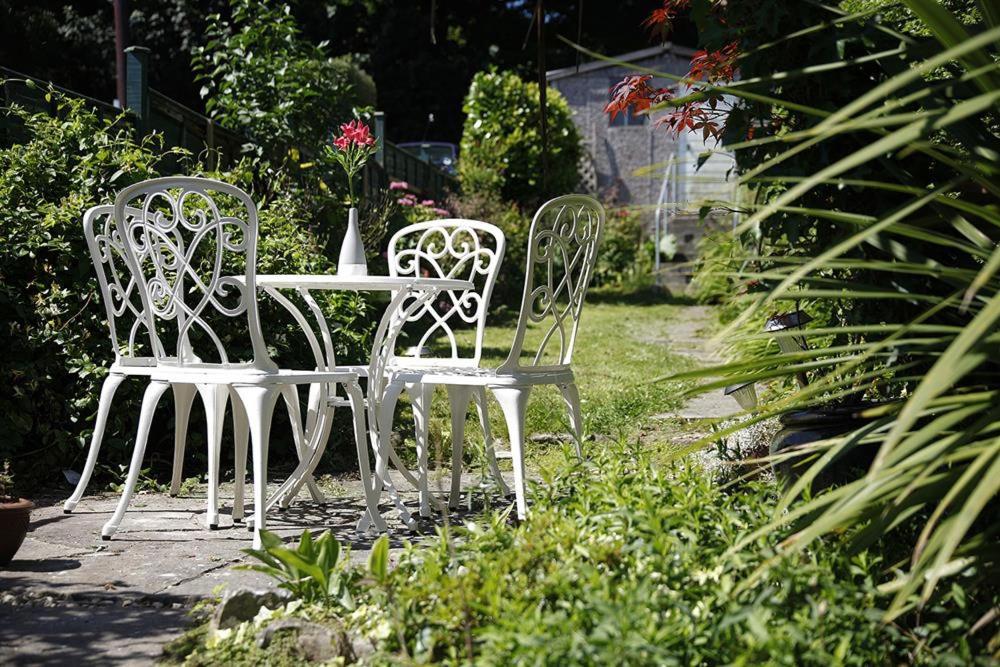 two white chairs and a table in a garden at 2 Bed in Mumbles oc-hh382 in The Mumbles
