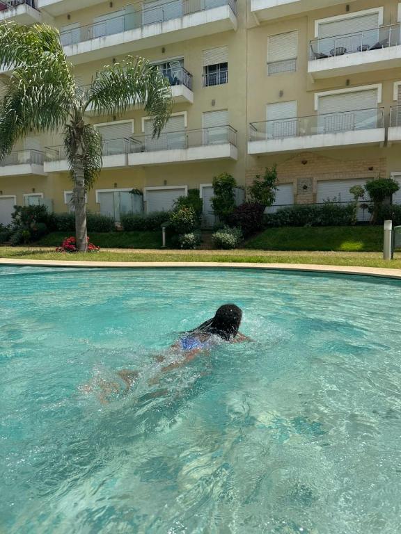 a person swimming in a swimming pool in a building at Résidence kettani in Zemmour Touirza