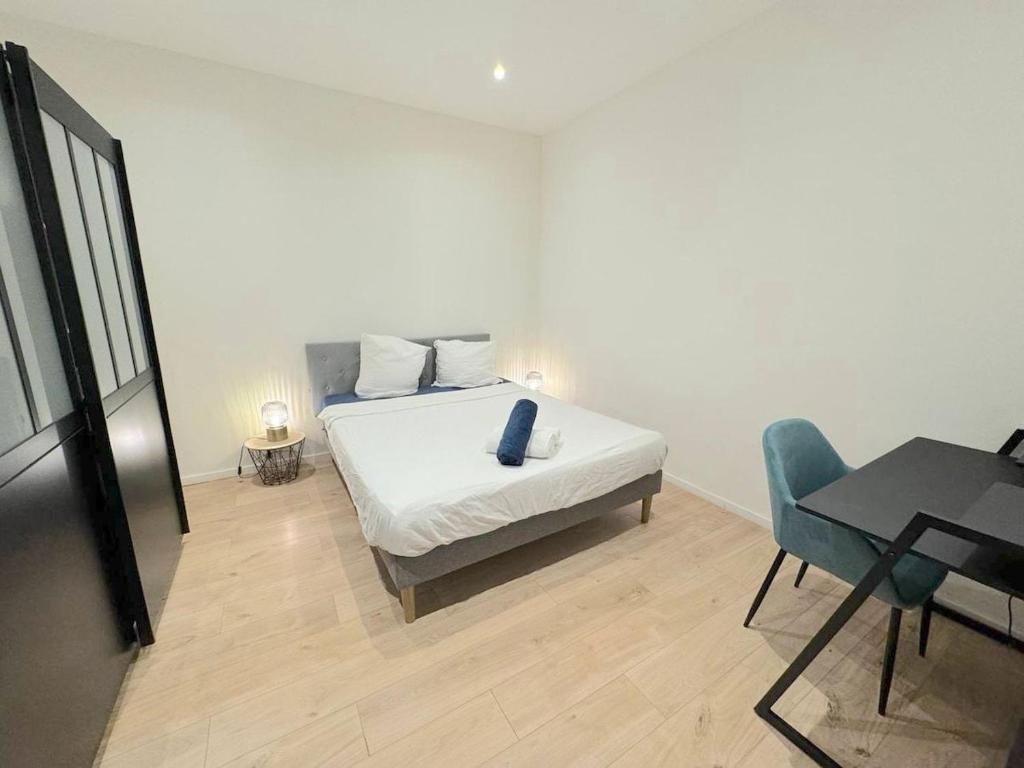 une chambre avec un lit, une table et une chaise dans l'établissement ⁂ 2P Rénové à 100m de la plage, à Nice