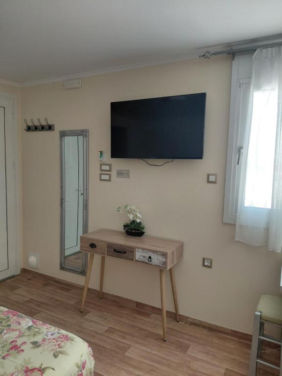 Habitación con mesa y TV en la pared. en 3SYS Apartment 403, en Kalamaki