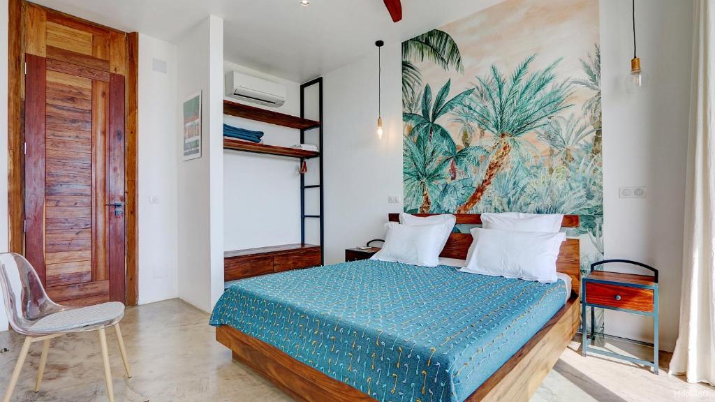 サン・ドニにあるVilla Cacao - avec piscine et vue mer - Nosy Beの壁に絵が飾られたベッドのある寝室