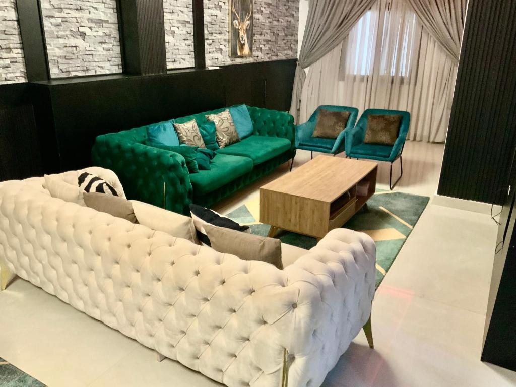 una sala de estar con un sofá y dos sillas en Appartement de rêve, en Dakar