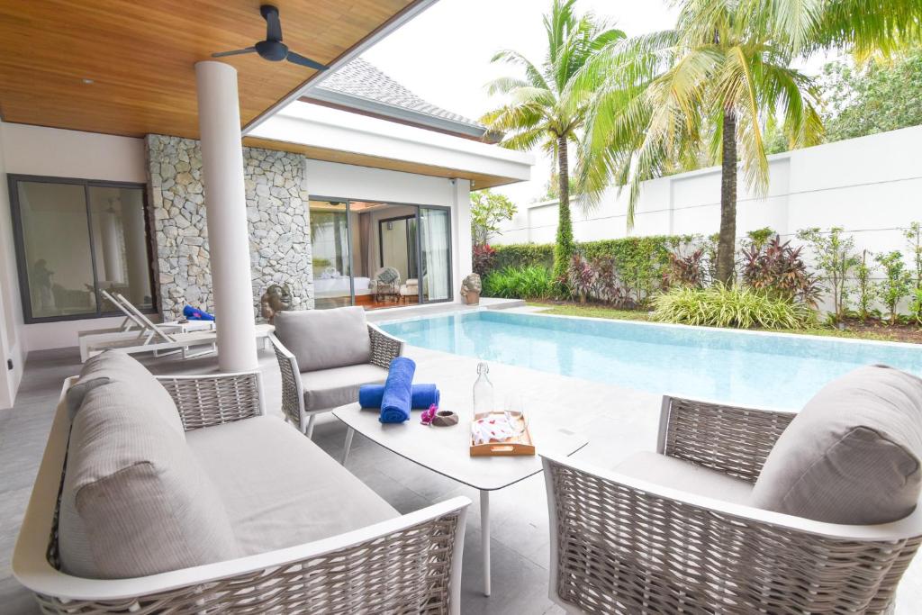 un patio extérieur avec des chaises et une piscine dans l'établissement Breeze Villa - Luxury Relaxation in Phuket, à Ban Thalat Choeng Thale