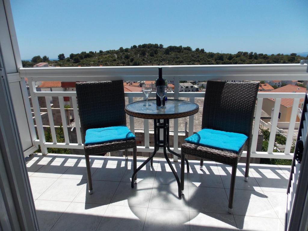 a table and chairs on a balcony with a view at Apartments and Rooms Jasna in Hvar
