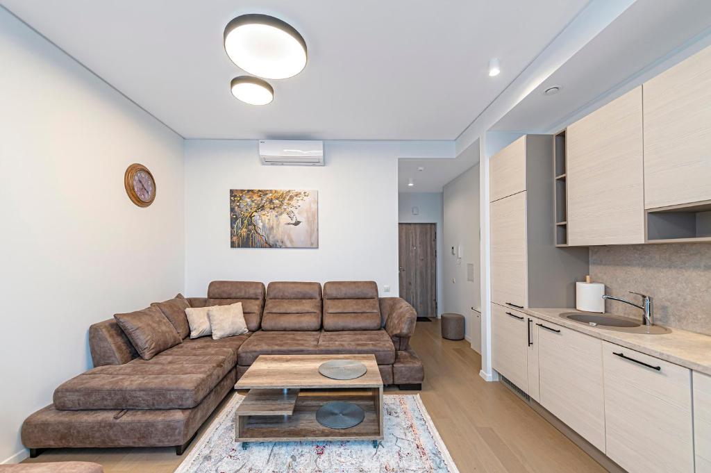 a living room with a couch and a table at Saulės Sonata apartamentai 5 in Druskininkai