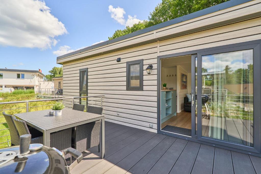 a small house with a deck with a table at Ostseecamp Salt & Sea in Scharbeutz