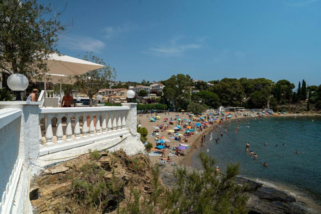 ein Strand mit vielen Leuten im Wasser in der Unterkunft Hotel Grifeu y Restaurant - Costa Brava in Llança