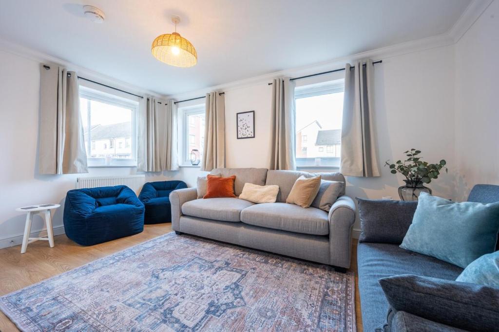 a living room with a couch and blue chairs at Atlanta's Residence by Tŷ SA in Newport