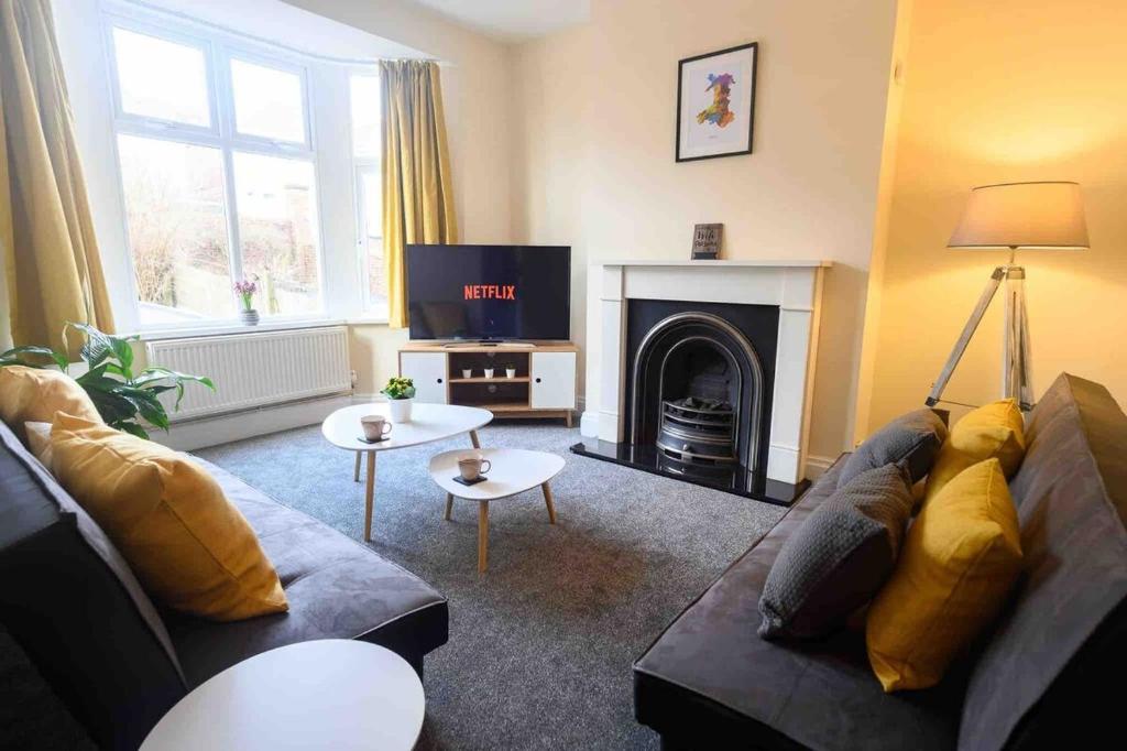 a living room with a couch and a fire place at Beechwood House by Tŷ SA - ICC & Celtic Manor in Newport