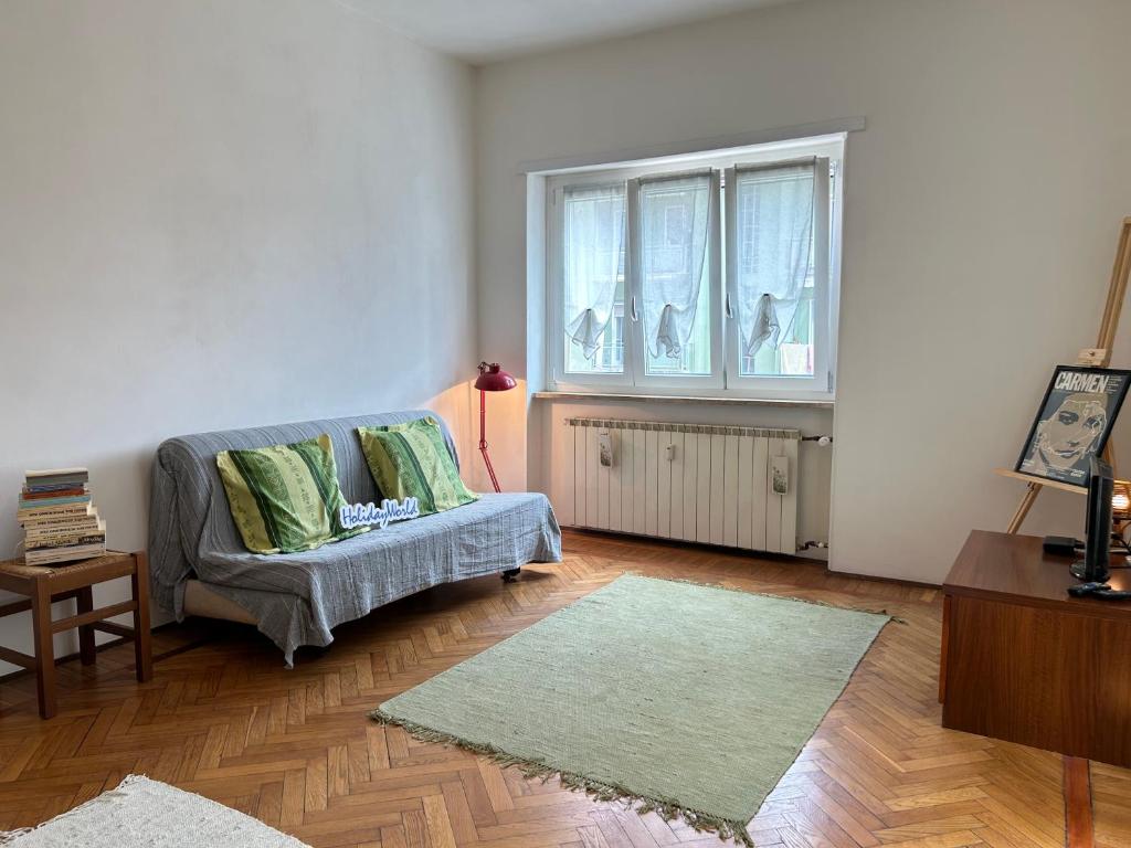 a living room with a couch and a window at Casa Rosy by Holiday World in Ivrea
