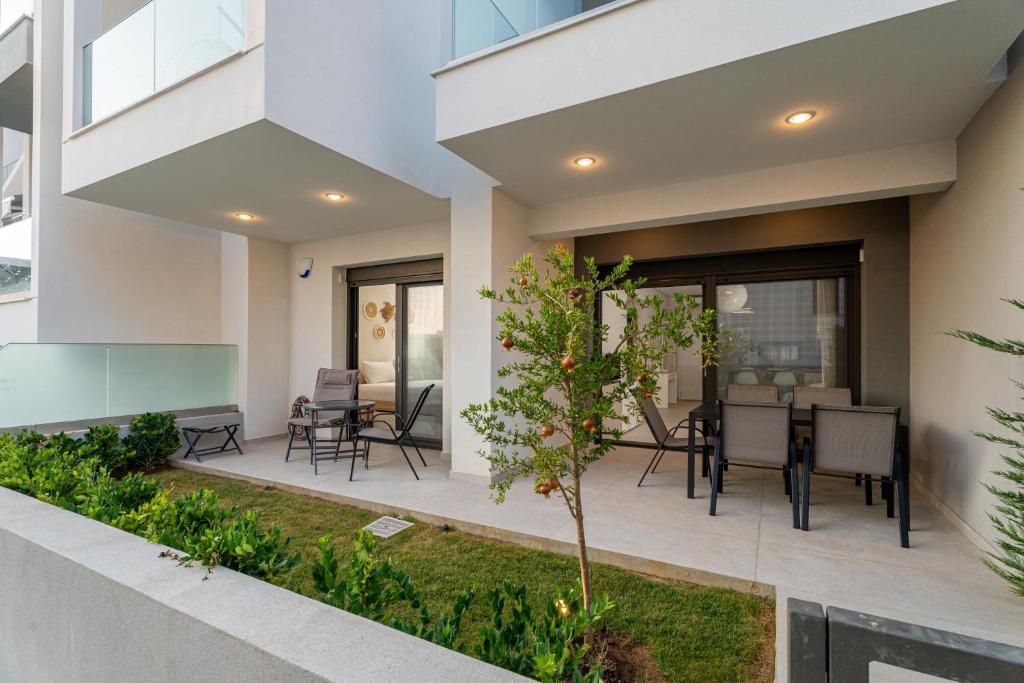 a patio with chairs and tables in a building at SithoniaRS Emerald Luxury Apartment in Nikiti