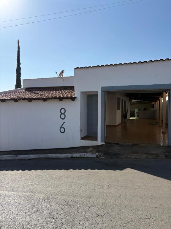 a white building with a garage with the number eight at Vovó Rubens Casa familiar in Piauí