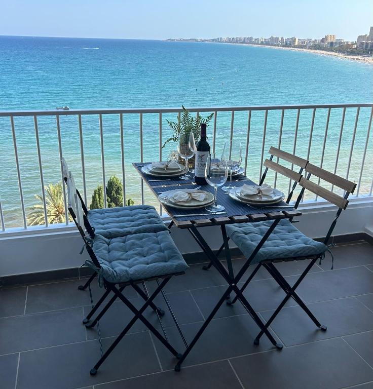a table and chairs on a balcony with the ocean at Tahití9H in El Campello