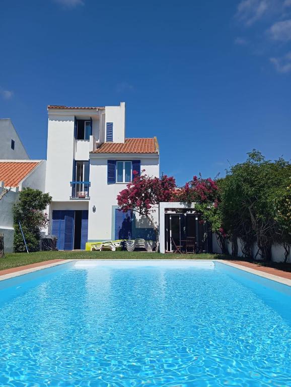 a villa with a swimming pool in front of a house at Villa Arrábida in Palmela