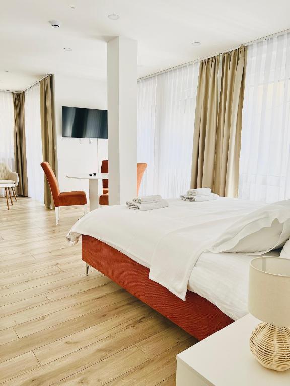 a hotel room with a large bed and a table at AMARIS Suites Sarajevo in Sarajevo