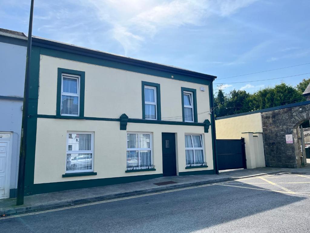 a white house with black trim on a street at The Old Post Office, Dunmore in Dunmore