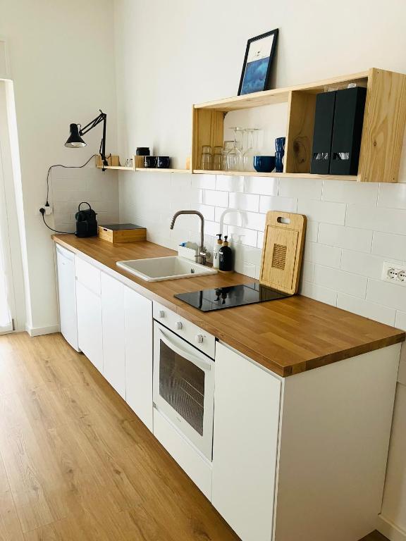 a kitchen with white cabinets and a wooden counter top at Casa Nina in Villasanta