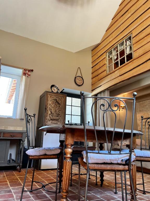 une salle à manger avec une table et des chaises en bois dans l'établissement Le grenier d'Odette, à Sainte-Gemme-la-Plaine