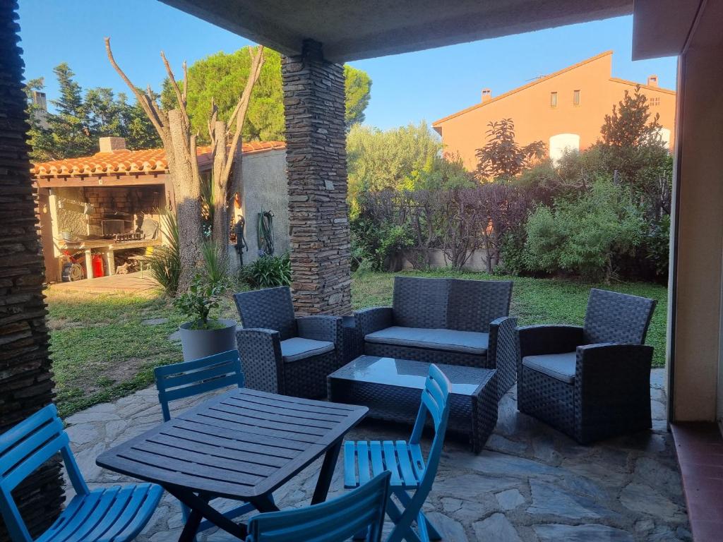 a patio with a table and chairs and a couch at T2 calme avec jardin terrasse et barbecue in Elne