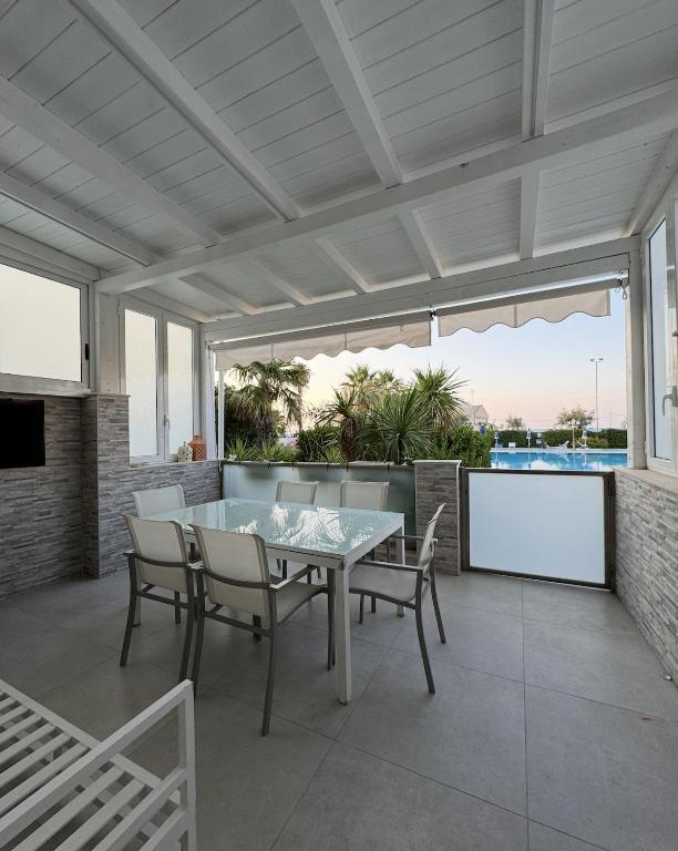 a dining room with a table and chairs on a patio at Villa con piscina L’Approdo in Barletta
