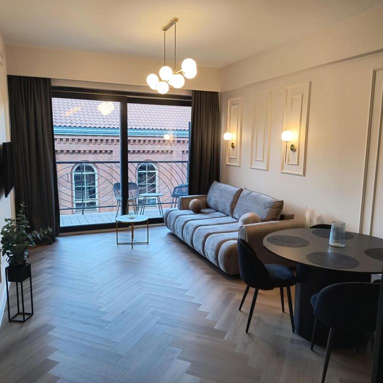 a living room with a couch and a table at Masuria Apartaments Ełk Centrum in Ełk