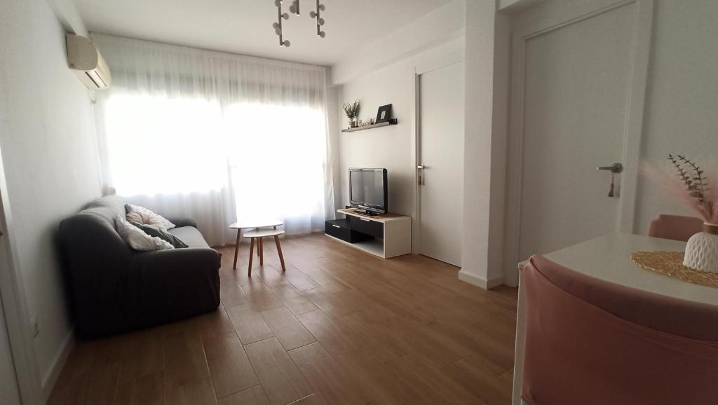 a living room with a couch and a television at Apartamento Murales de Talavera in Talavera de la Reina