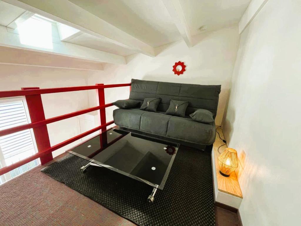 un salon avec un canapé et une clôture rouge dans l'établissement Sea Sun Cocoon, à La Rochelle