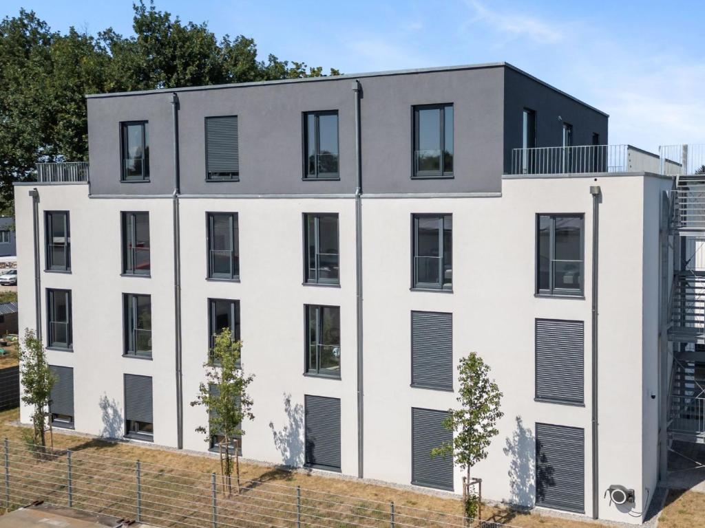 un edificio bianco con finestre nere di LivingBoxx Karlsruhe - Messe I neuwertige Apartments mit Küche a Rheinstetten