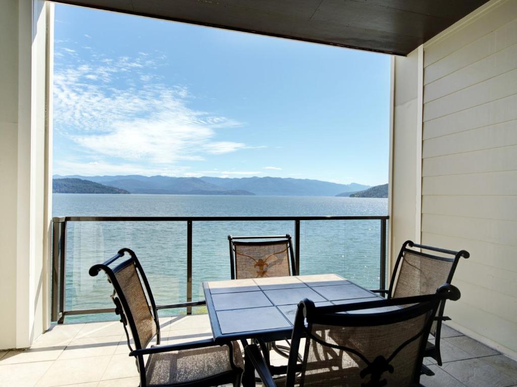 a table and chairs on a balcony with a view of the water at Seasons at Sandpoint - Managed by Elite Alliance in Sandpoint