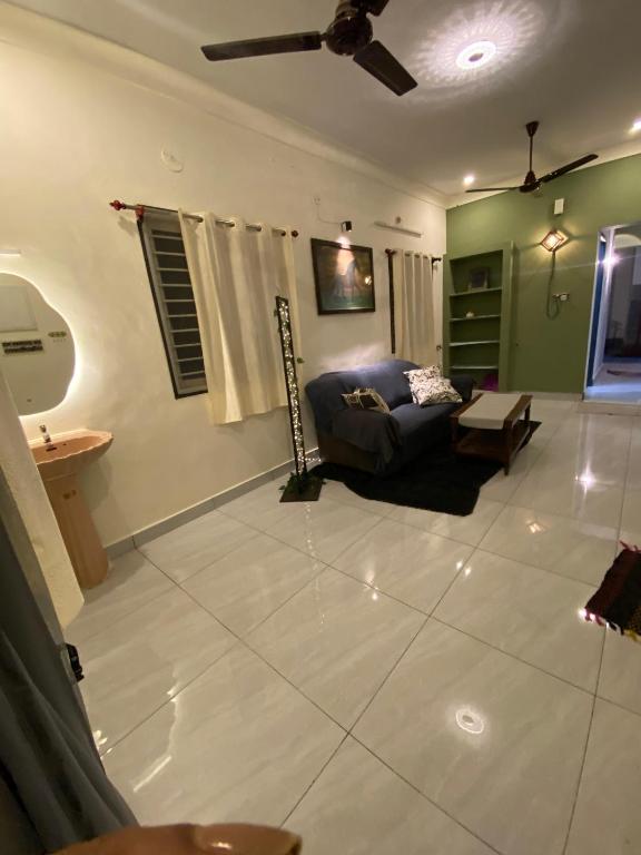 a living room with a couch and a ceiling fan at Heritage homestay in Puducherry