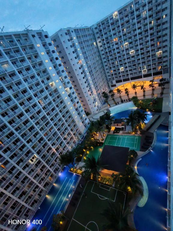 马尼拉Jessy's Suites的享有一座带网球场的大型建筑的空中景致