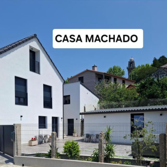 a sign for a casa machado in front of a white building at Casa Machado in Cangas de Morrazo