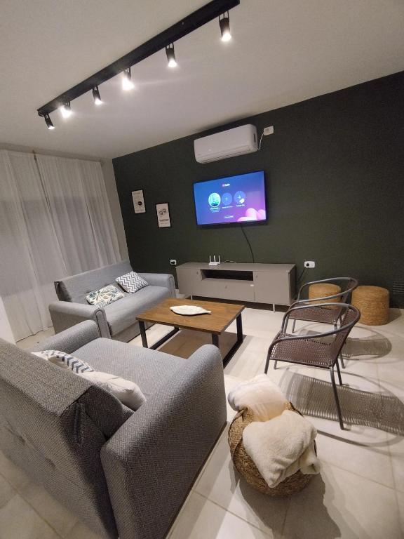 Una sala de estar con sofás y un televisor de pantalla plana. en Finca Dallas, en Santiago del Estero
