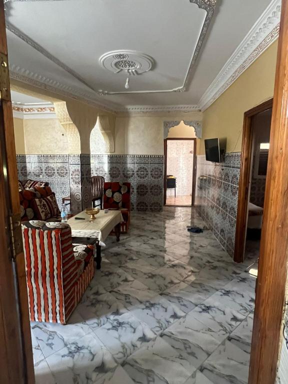 Habitación con mesa, sillas y suelo de mármol. en Ezzaimi apartment, en Tánger