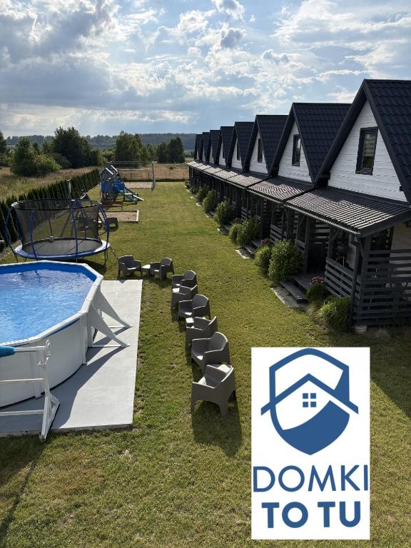 a building with a pool and a sign for a domiki to tub at DomkiToTu in Jarosławiec