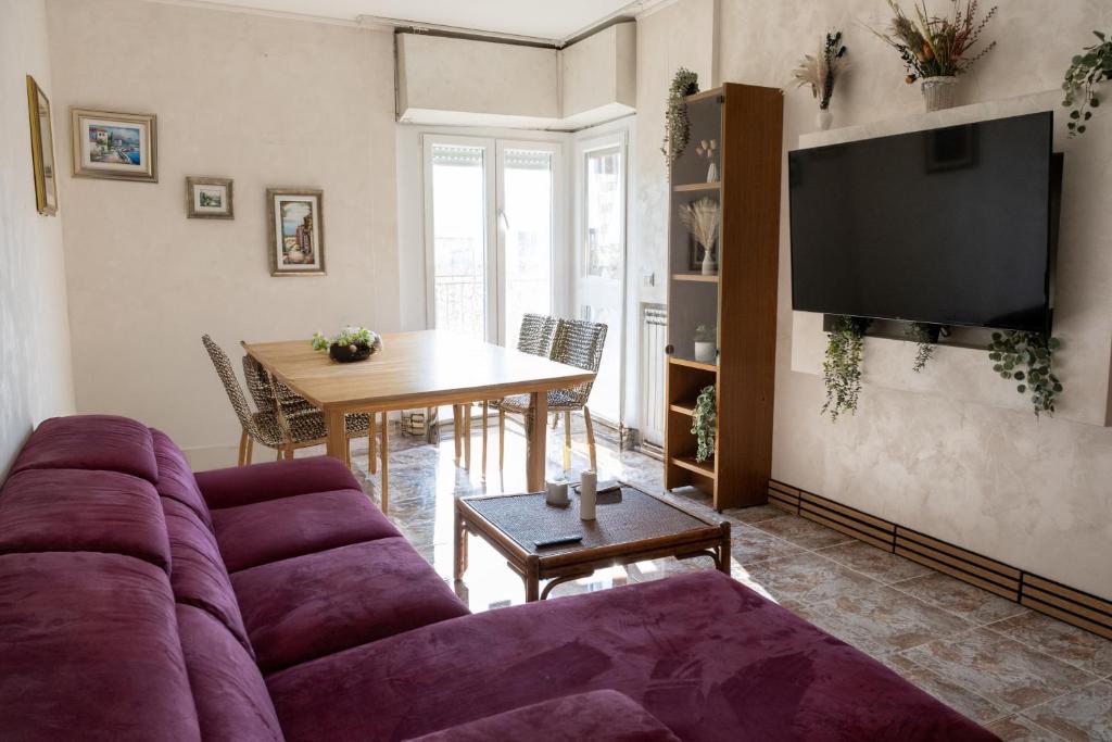 a living room with a purple couch and a table at Domus Laurentia in Rome
