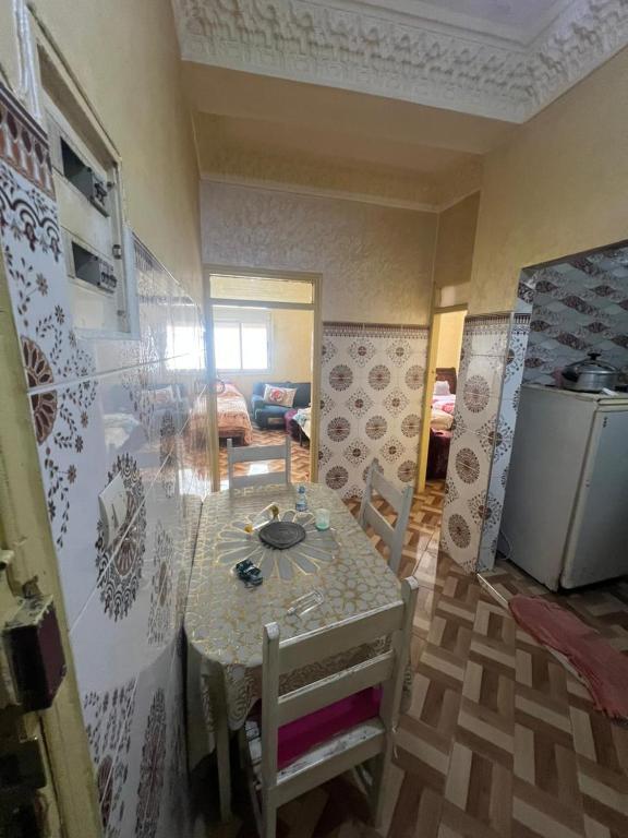a dining room with a table and a room with a kitchen at ezzaimi apartment playa in Tangier