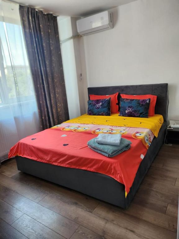 a bedroom with a bed with a red and yellow blanket at Exceptional Apartment - Gara de Nord in Bucharest