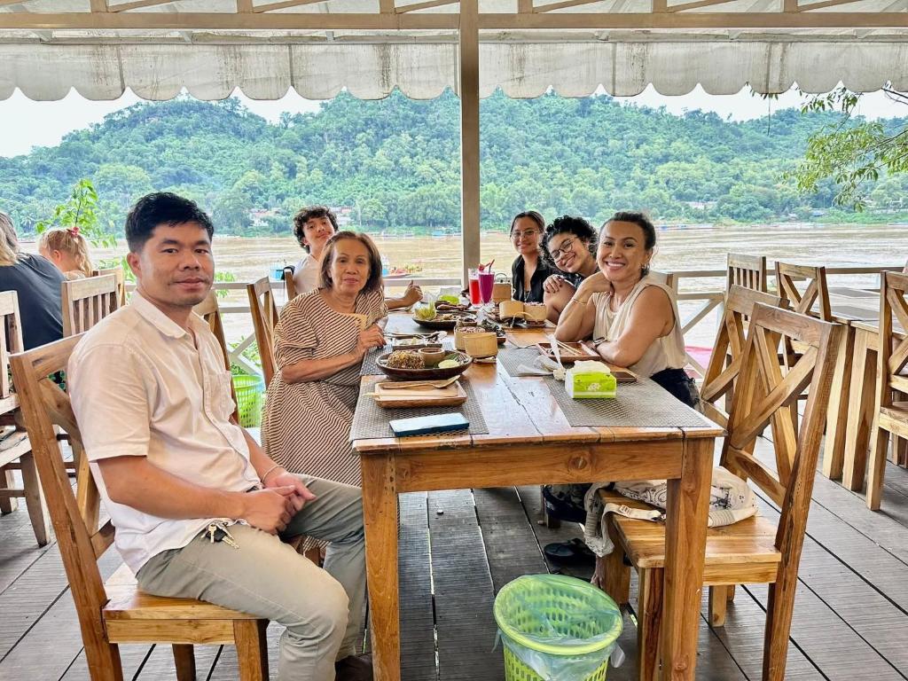 琅勃拉邦3 days tour to visit surroundings of Luang Prabang的一群人围坐在木桌旁