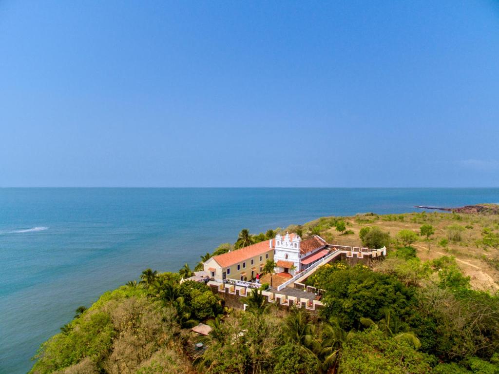 uma vista aérea de uma casa numa colina junto ao oceano em Fort Tiracol Heritage Hotel em Arambol