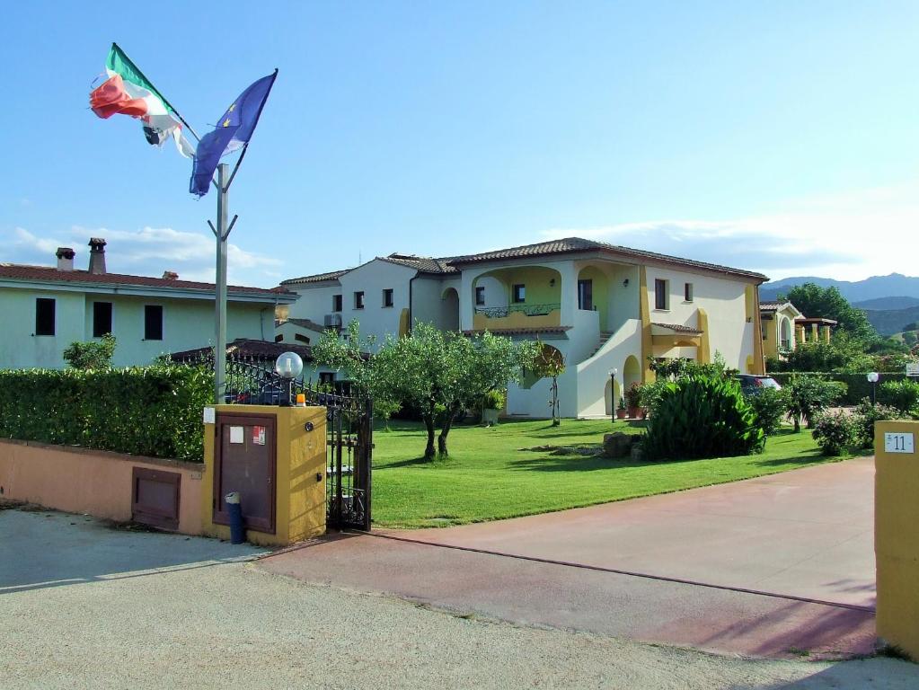 a house with a flag on a pole in a yard at Case Vacanze San Silvestro in Budoni