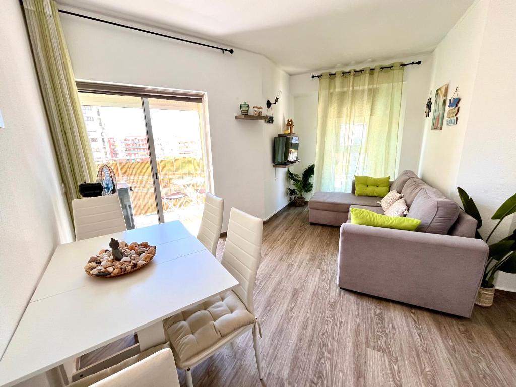 a living room with a table and a couch at Casa da Praia na Torre Castelo in Armação de Pêra