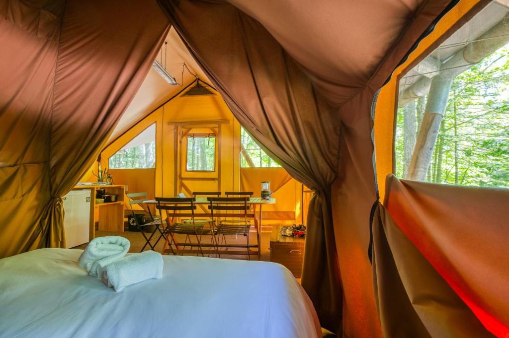a bedroom with a bed in a tent at Huttopia Les Deux Lacs - Laurentides in Mont-Blanc