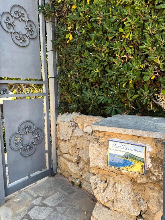 a door to a building with a sign on a stone wall at Marilù Casa Vacanza in San Vito lo Capo