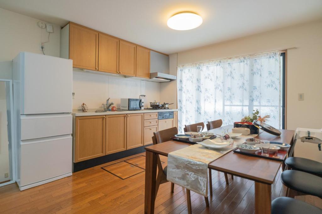 a kitchen with a table and a dining room at CEREZO House in Osaka