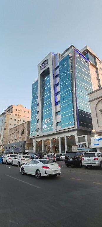 a large building with cars parked in a parking lot at Bram Hotel in Jeddah