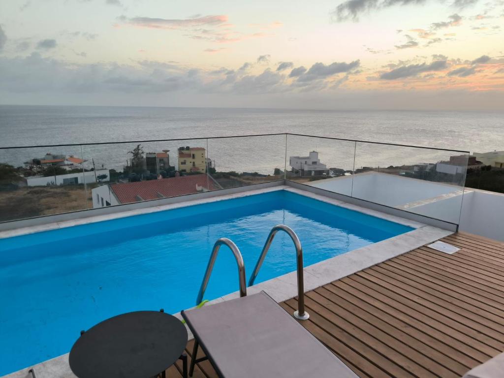 a swimming pool on a balcony with a view of the ocean at Apartamento Praia JOIA in Praia